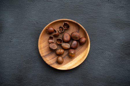 Top view chestnuts on plate with copy space on darkの写真素材