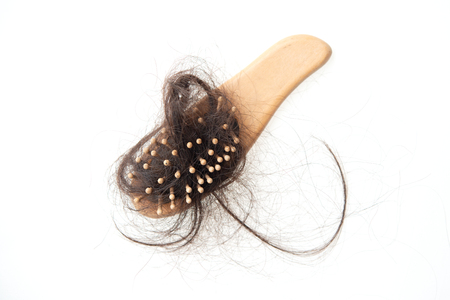 Hairloss problem. Brush with lost hair on it, isolated on white background.の写真素材