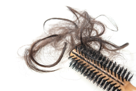 Hairloss problem. Brush with lost hair on it, isolated on white background.の写真素材