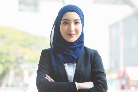 Portrait of Muslim woman in business suit, arms crossed and smile looking at camera.の写真素材