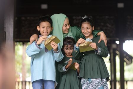 Muslim family, children received money packet as blessing, Hari Raya Eid Al-Fitr concept.の写真素材