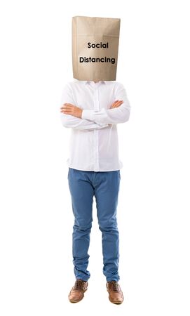 Social distancing to avoid the spread of coronavirus. Man covered head with paper bag.の写真素材