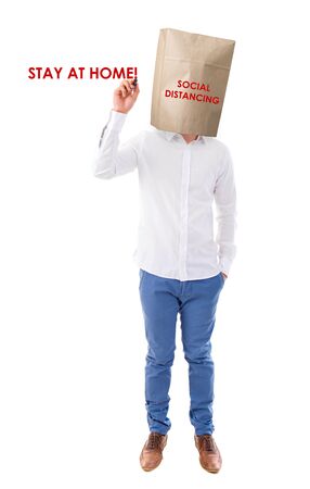 Social distancing to avoid the spread of coronavirus. Man covered head with paper bag.の写真素材