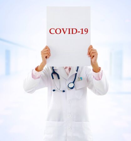 Medical staff holding a card with covid 19 on it.の写真素材