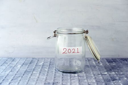 Coins in glass money jar with 2021 label, financial concept.の写真素材