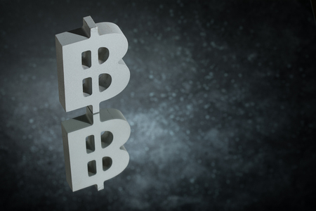 Bitcoin Currency Symbol or Sign With Mirror Reflection on Dark Dusty Backgroundの写真素材