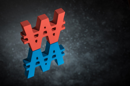 Red and Blue South Korean Currency Symbol or Sign Won With Mirror Reflection on Dark Dusty Backgroundの写真素材