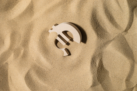 Euro Symbol lies on the Sand in Direct Sunlightの写真素材