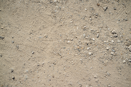Dusty Road with Small Rocks, Dirt, Footprints, Car and Bicycle Traces Textureの写真素材