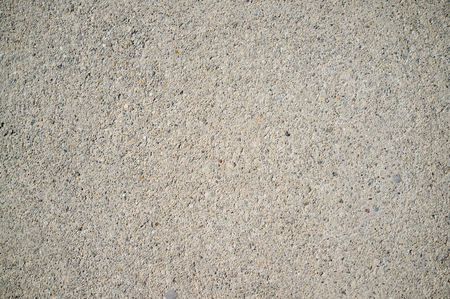 Texture of Old Weathered Concrete Wall with Small Rocks on Direct Sunlightの写真素材