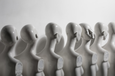 White Woman Torso Figurines Standing in The Line All Looking to Same Direction except of One all shoot on White Bright Backgroundの写真素材