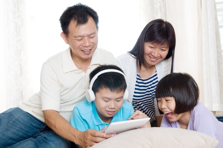 Asian family having fun with tablet computerの写真素材
