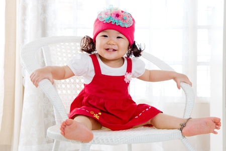 Smiling asian girl sitting on the chairの写真素材