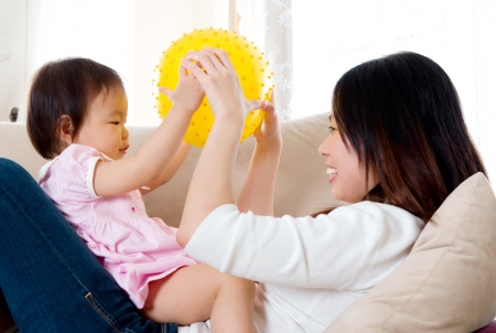 Asian mother playing with her baby girlの写真素材