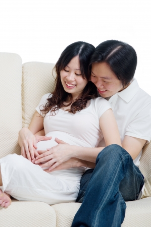 Asian man holding pregnant wife s bellyの写真素材