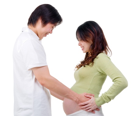 Asian man holding his pregnant wife s bellyの写真素材