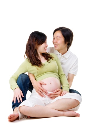 Asian pregnant woman sitting on the floor looking at her husbandの写真素材