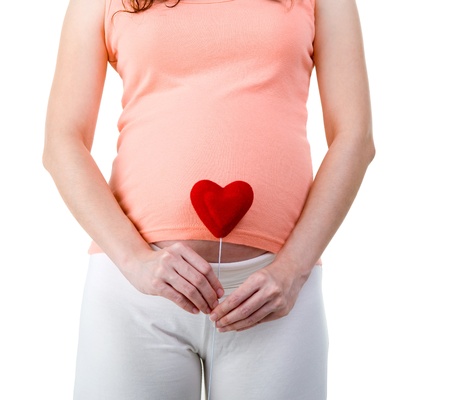pregnant woman holding love shape isolated on white backgroundの写真素材