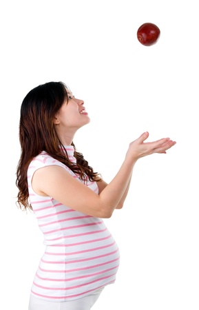 pregnant woman throwing an apple upwardの写真素材