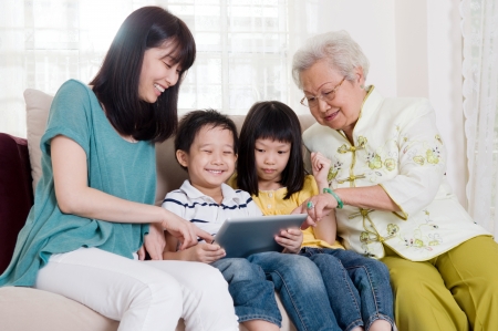 Asian three generations family having fun with tablet computer