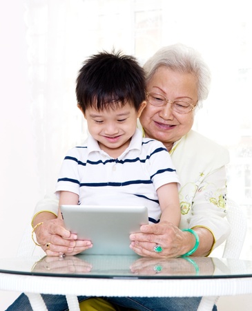 Asian grandmother and grandson using tablet computerの写真素材