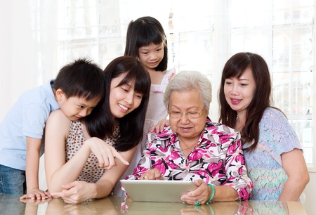 Asian senior woman learns to use tablet computerの写真素材