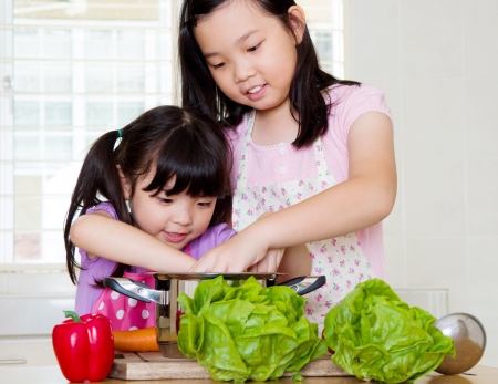 Little asian girls cookingの写真素材