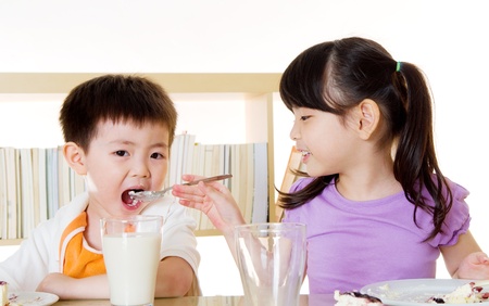 Asian girl feeding her brotherの写真素材