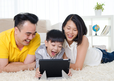 Asian family having fun with tablet computerの写真素材