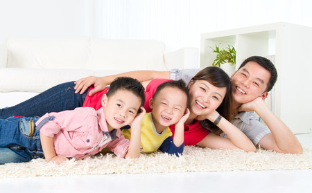 Asian family lying on the floor and smilingの写真素材
