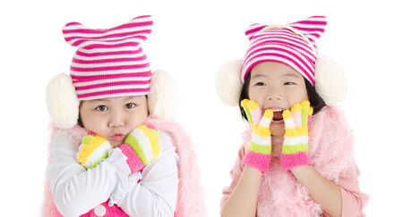 Cute asian girls in winter clothing with funny expression isolated on whiteの写真素材