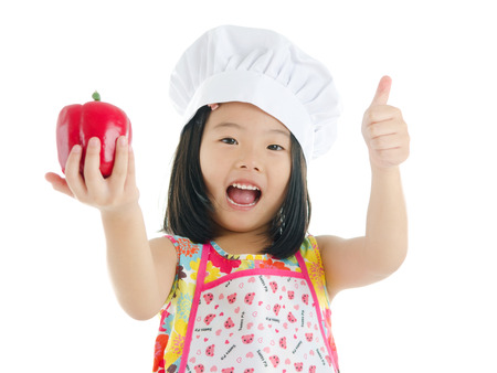 Asian girl holding a capsicum and thumbs up. healthy eating conceptの写真素材