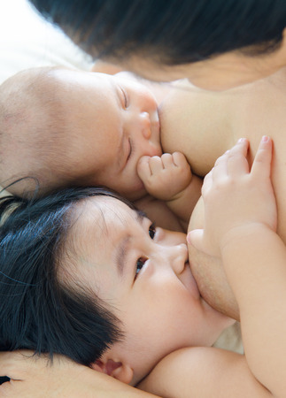 Breastfeeding two kids at the same timeの写真素材