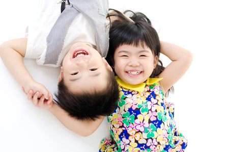 Lovely asian kids lying on the floorの写真素材