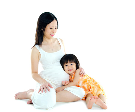 Little asian girl listening to her pregnant mother\\\\の写真素材