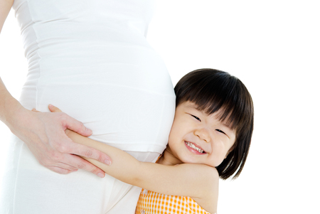 Little asian girl listening to her pregnant mother\\\\の写真素材