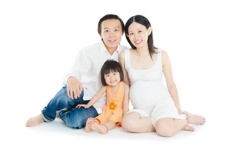 Indoor portrait of pregnant woman together with husband and daughterの写真素材