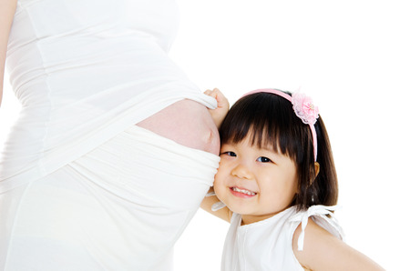 Asian girl listening to her pregnant mother\\\\の写真素材