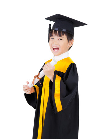 Cheerful asian boy in graduation gown and mortarboardの写真素材