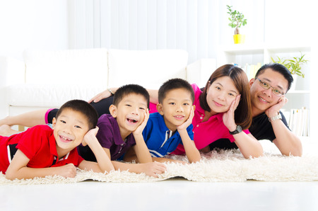 Asian family lying on the floorの写真素材