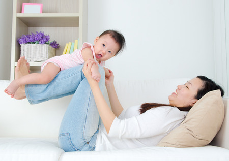 Asian mother playing with her babyの写真素材