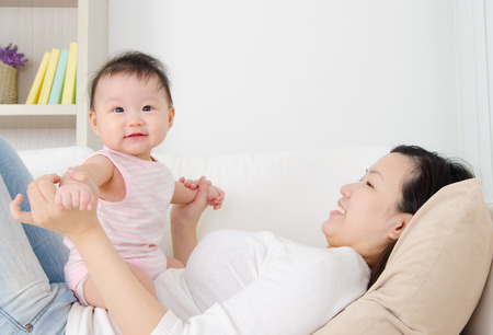 Asian mother and her cheerful babyの写真素材