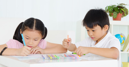 Asian kids drawing with coloured pencilsの写真素材