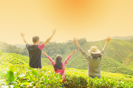 Asian family open arms enjoying the beautiful sunsetの写真素材