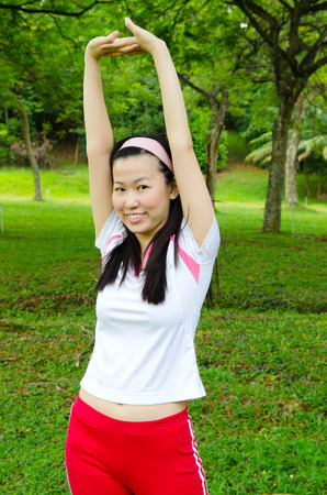 Young asian woman stretching her handsの写真素材