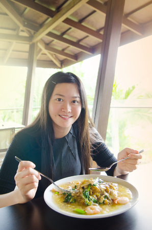 Young asian woman eating noodlesの写真素材