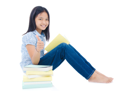 Asian girl reading and raised her thumb upの写真素材