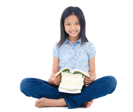 Asian girl sitting on the floor and reading isolated on white backgroundの写真素材
