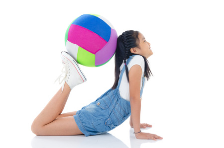 Asian girl doing exercise using a balance balloの写真素材