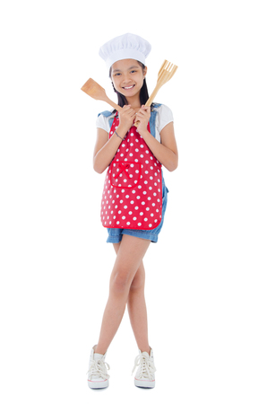 Asian girl wearing apron and holding cooking utensilの写真素材